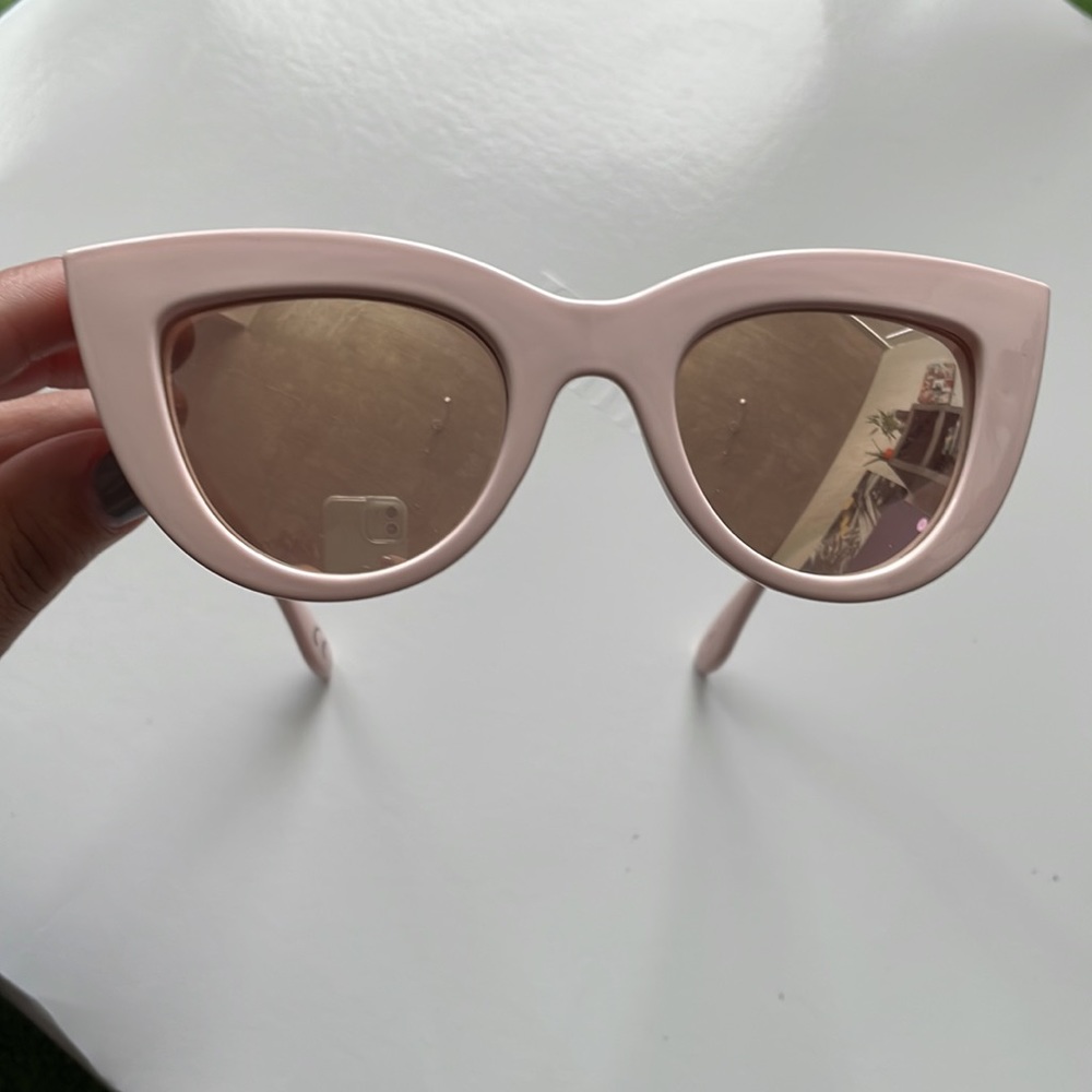 Light pink frame cat eye sunglasses with a mirrored Lens.